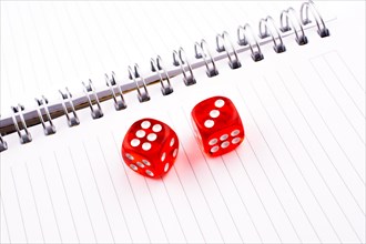 Red dice on a a notebook on a white background