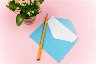 Pen on a blue envelope with a letter with a pink background