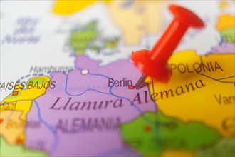 Berlin marked with a red thumbtack on a map with an out-of-focus background