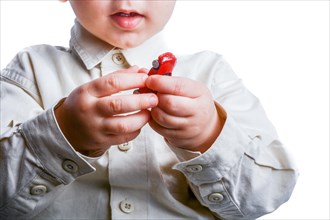 Baby hand holding a red car on a white background