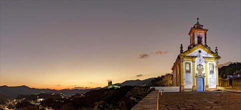 Panoramic image with the baroque style churches and the city illuminated on top of the hill in Ouro Preto