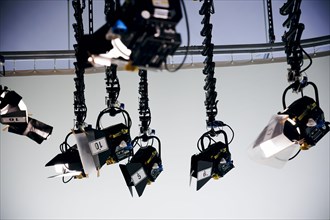 Spotlights hang from the ceiling in a television studio. Berlin