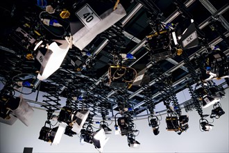 Spotlights hang from the ceiling in a television studio. Berlin