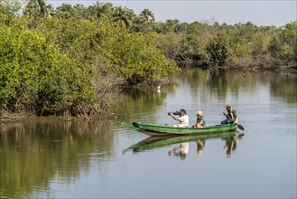 Tourists with canoe on the Kotu River watching and photographing birds