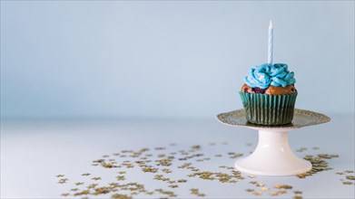 Candle cupcake cakestand against blue background