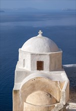White-washed Agios Nikolaos Castle Church with blue sea in background