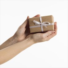 Hands holding gift with bow