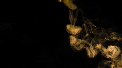 Yellow smoke curl black background with copy space writing text