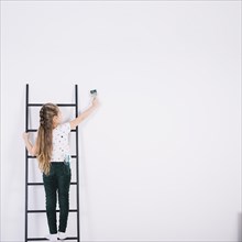 Little girl ladder painting wall