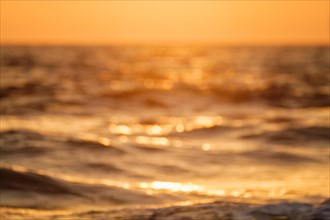 Ocean on sunset backlit with sun defocused blurred background