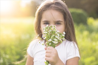 Girl smelling white flowers
