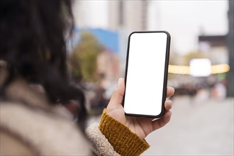 Woman holding blank smartphone outside