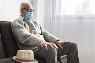 Man with medical mask sitting nursing home
