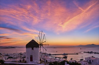 Famous traditional Greek windmill overlook civil port and harbor of Mykonos