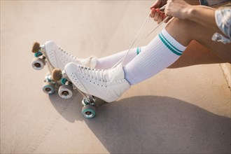 Low section woman tying roller skate lace