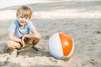 Playful kid sitting wind ball