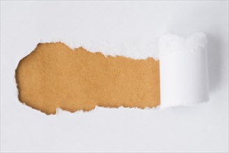 Ripped paper revealing cardboard