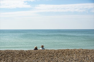 Two people sitting and looking at the sea