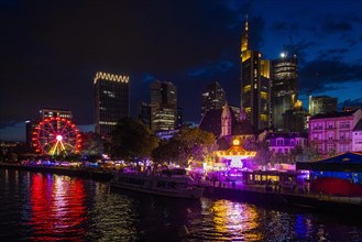 The colourful lights of the Mainfest shine in the evening. The Mainfest on the Mainkai