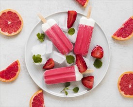 Top view yummy popsicles plate with red grapefruit