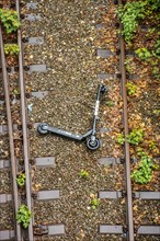 An electric scooter lies overturned between two railway tracks in Duesseldorf