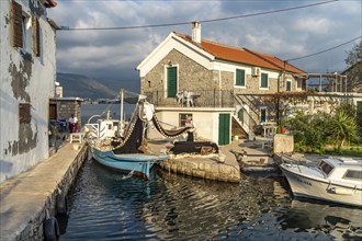Fisherman with his net in the small harbour of the fishing village Bjelila