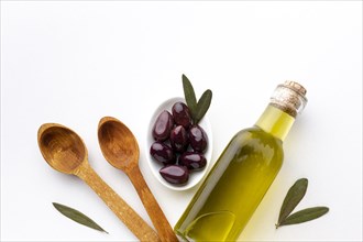 Olive oil bottle purple olives wooden spoons