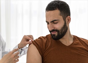 Front view doctor vaccinating bearded man