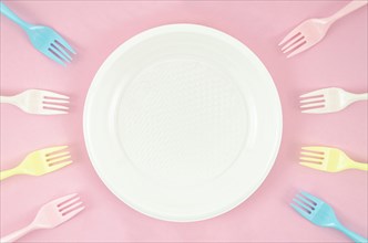 Colorful plastic dishes pink background