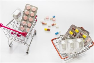Pills medicine blisters inside two shopping cart white background