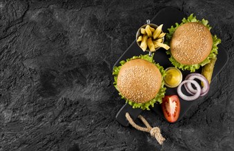 Top view burgers fries cutting board with pickles copy space