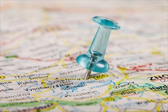 Turquoise colored pushpin stucked world map