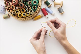 Hands working with needle sewing thread