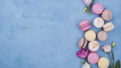 Flat lay assortment macarons with roses copy space