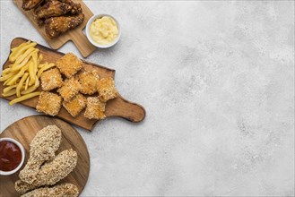 Top view fried chicken with sauces nuggets chopping boards with copy space
