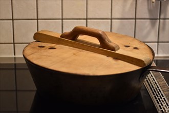 Preparation of steam noodles in rustic old steam noodle pan with wooden lid