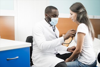 Black doctor using stethoscope