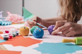 Female artist hand making cartoon faces using craft equipment