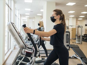 Side view women exercising gym during pandemic