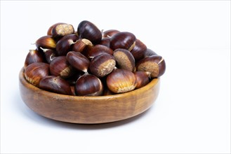 Pile of chestnuts in a wooden bowl isolated on a white background