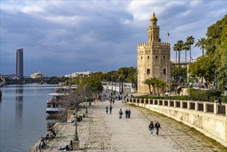 Waterfront on the Guadalquivir River with the historic Torre del Oro tower in Seville