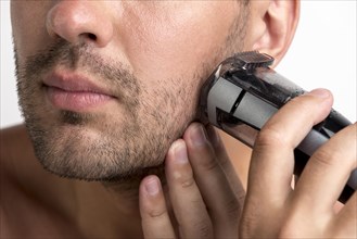 Man shaving with black trimmer
