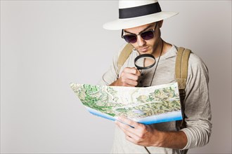Hipster man with map magnifying glass