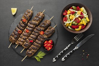 Flat lay tasty kebab slate with other dish cutlery