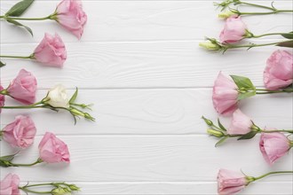 Flat lay arrangement pink roses wooden background