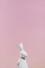 White rabbit figurine pink background