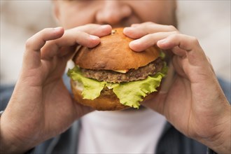 Close up man eating burger