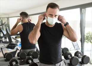 Man putting medical mask gym