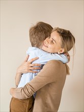 Adorable young boy hugging his mother