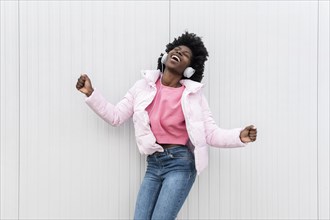 Portrait young woman with headphones jumping